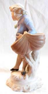 AN OLD SAND GLAZE FIGURINE OF A MAN IN A STRONG WIND  
