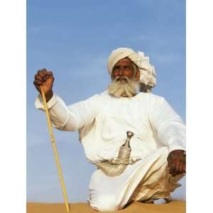  Bedouin Man Kneels on Top of a Sand Dune in the Desert 