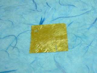 Carefully remove the paper sheet from the gold leaf.
